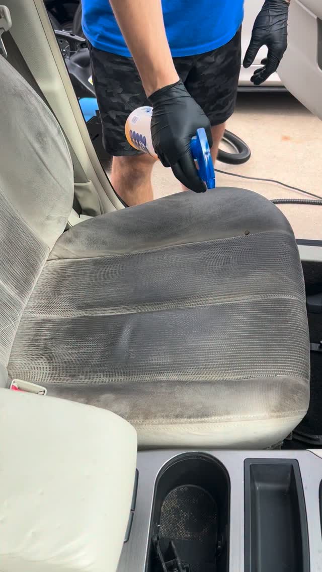 Apex detailer spraying cleaner on a stained cloth car seat