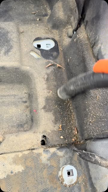 Vacuum nozzle working across a dusty floor pan