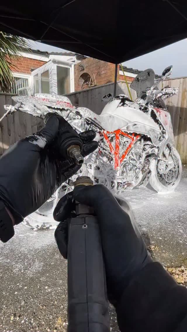 Motorcycle covered in snow foam during an Apex exterior wash